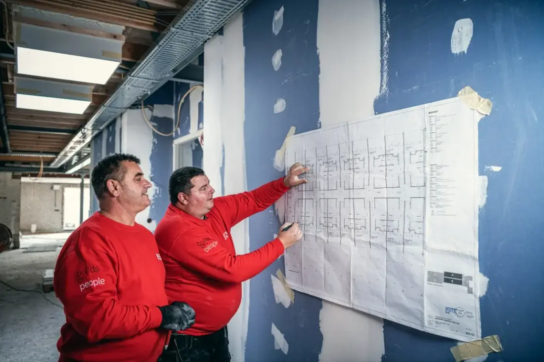 Doi muncitori BWB Flex studiază un plan de construcție